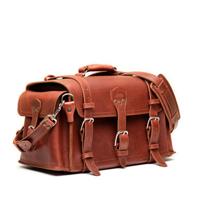 Side Pocket Leather Duffle Bag in Chestnut, angled front side view with buckle straps