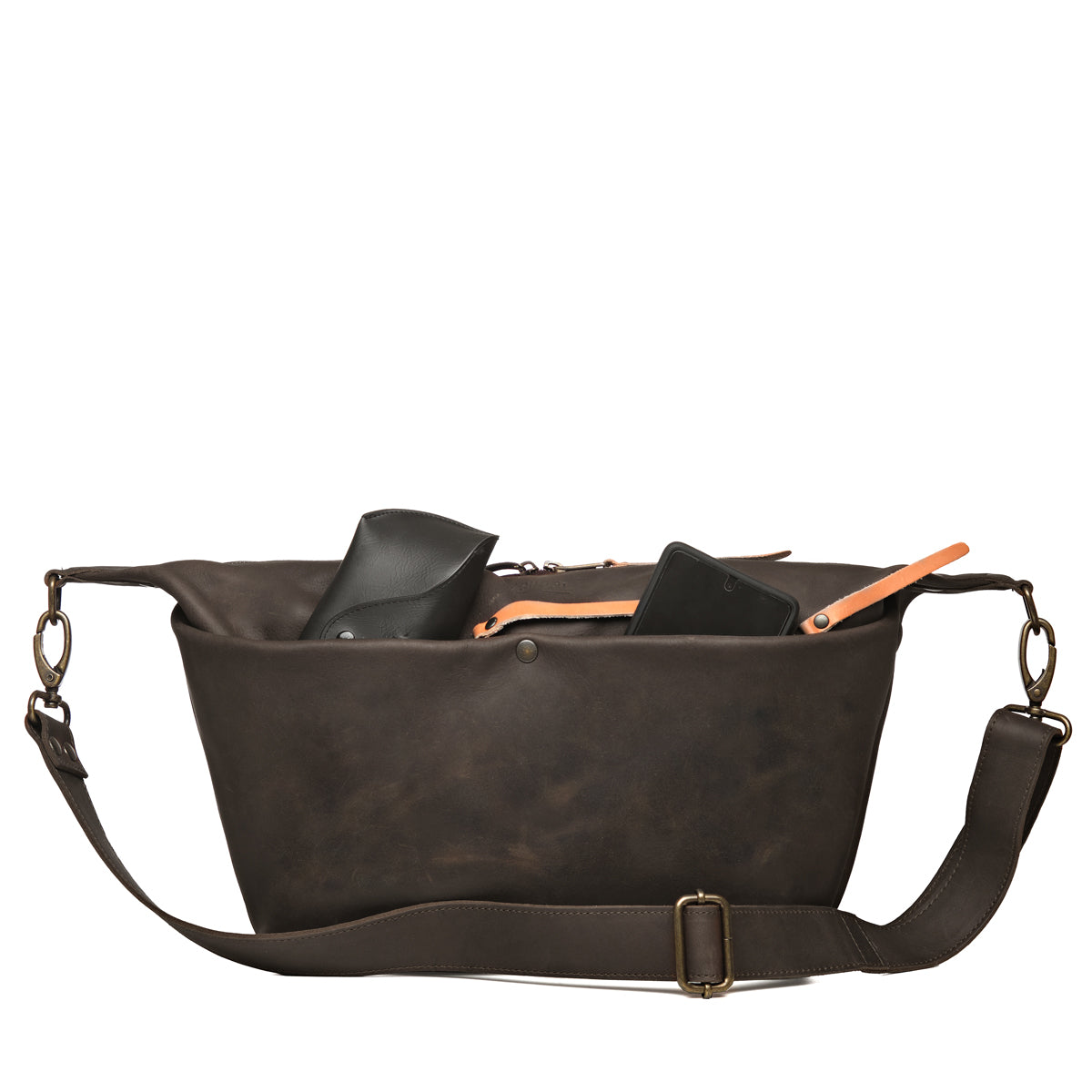 London Sling Large in Black, front view with a phone and glasses case peeking from the open top