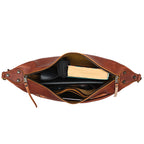 London Sling Large in Chestnut, top view unzipped with a book, tablet and sunglasses inside