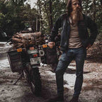 20" Waterbag strapped to a loaded adventure motorcycle beside a bearded rider on a forest trail