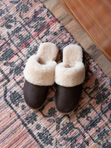 Women's Sheepskin Slippers in Dark Coffee Brown, top-down view of pair on a patterned rug