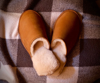 Women's Sheepskin Slippers in Tobacco, top view on a plaid blanket