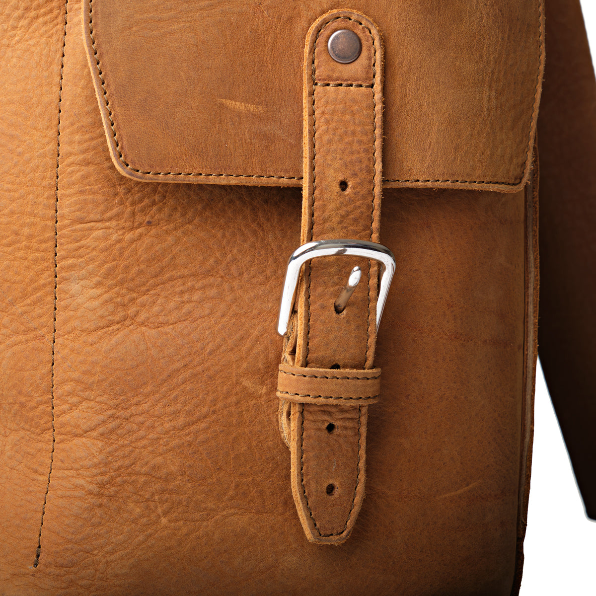 16" Drawstring Backpack in Tobacco, close-up of side pocket strap and buckle on tumbled leather