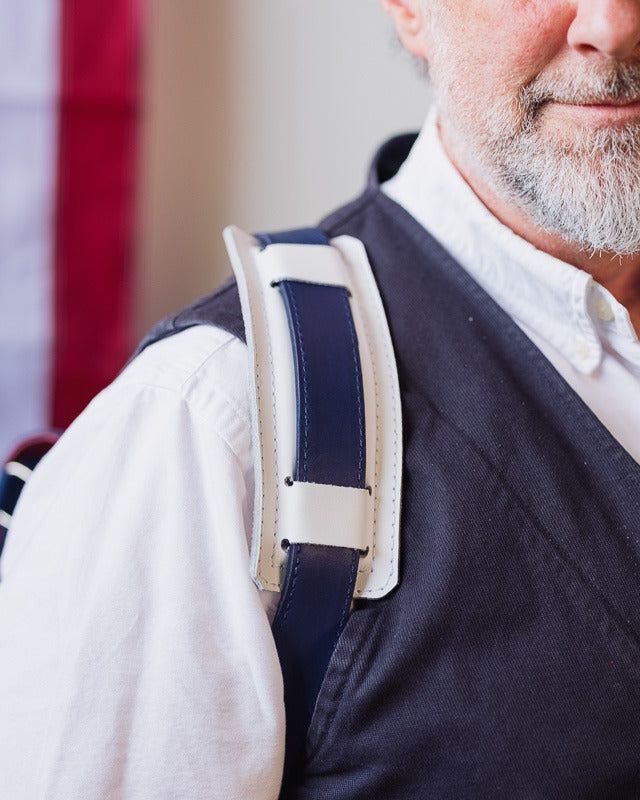 Close-up of the bundle's red, white and navy shoulder strap worn over a man's shoulder