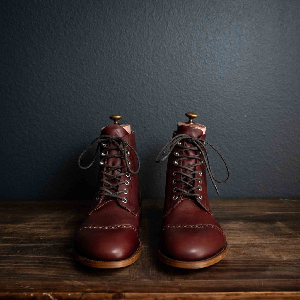 Officer Boot in Oxblood, front view of pair with dark laces and boot trees