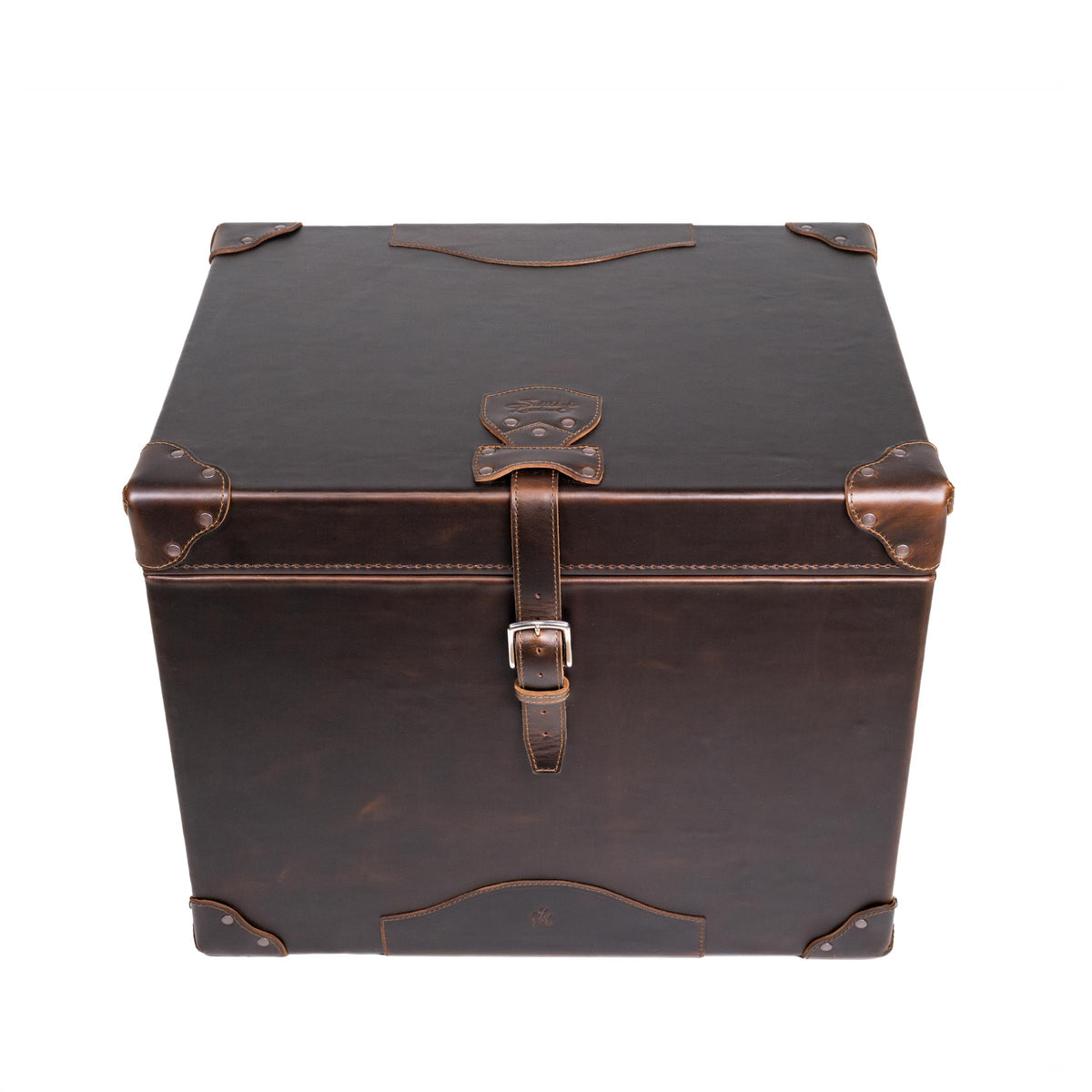Leather Small Trunk in Dark Coffee Brown, closed front view from above showing lid, embossed logo patch and buckled strap