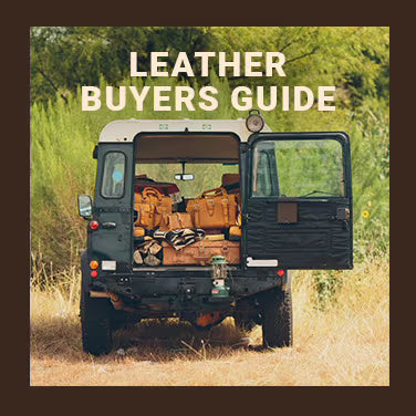 Leather Buyers Guide: a vintage four-by-four with its back door open, packed with leather bags, parked in tall grass