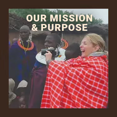 Our Mission & Purpose: a laughing woman wrapped in a red checked blanket holds a video camera among women and children in beaded collars