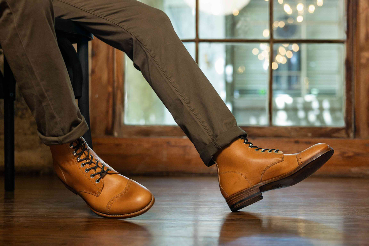 Officer's Boot in English Tan, worn with olive trousers while seated by a window