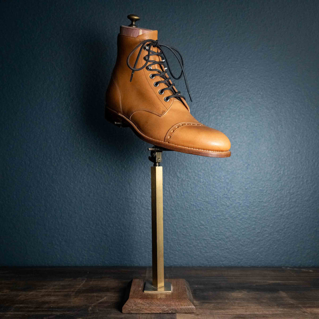 Single high quality English tan leather Officer's Boot on a brass display stand, side view