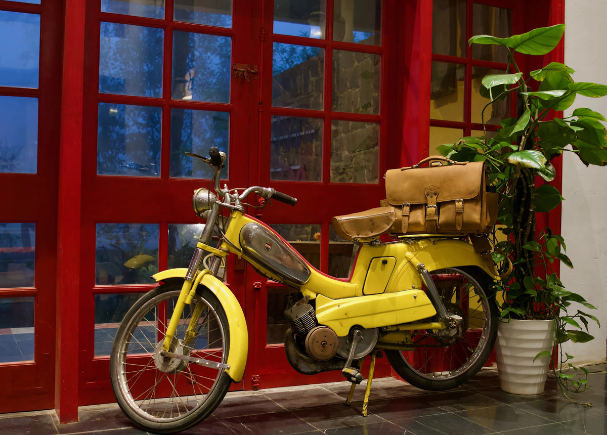 Tan Tobacco Front Pocket Leather Briefcase on the seat of a yellow vintage moped