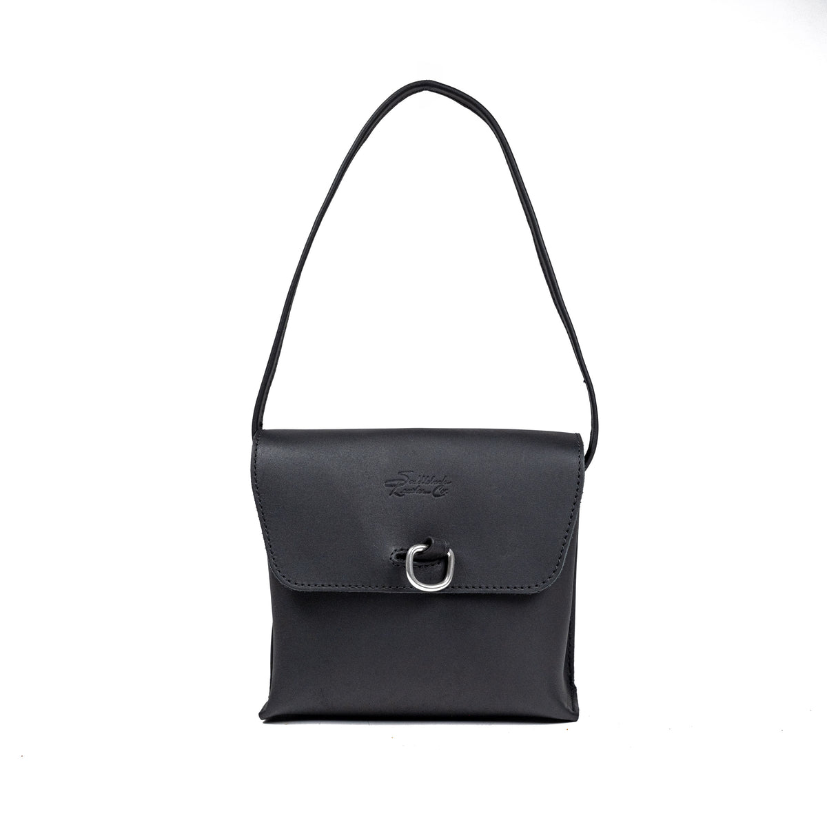 Leather Organizer Bag in Black, front view hanging from its strap with flap and metal ring closure