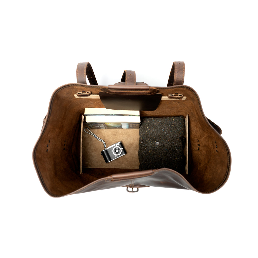 20" Waterbag in Dark Coffee Brown, open top-down view of interior with books, camera and a sweater
