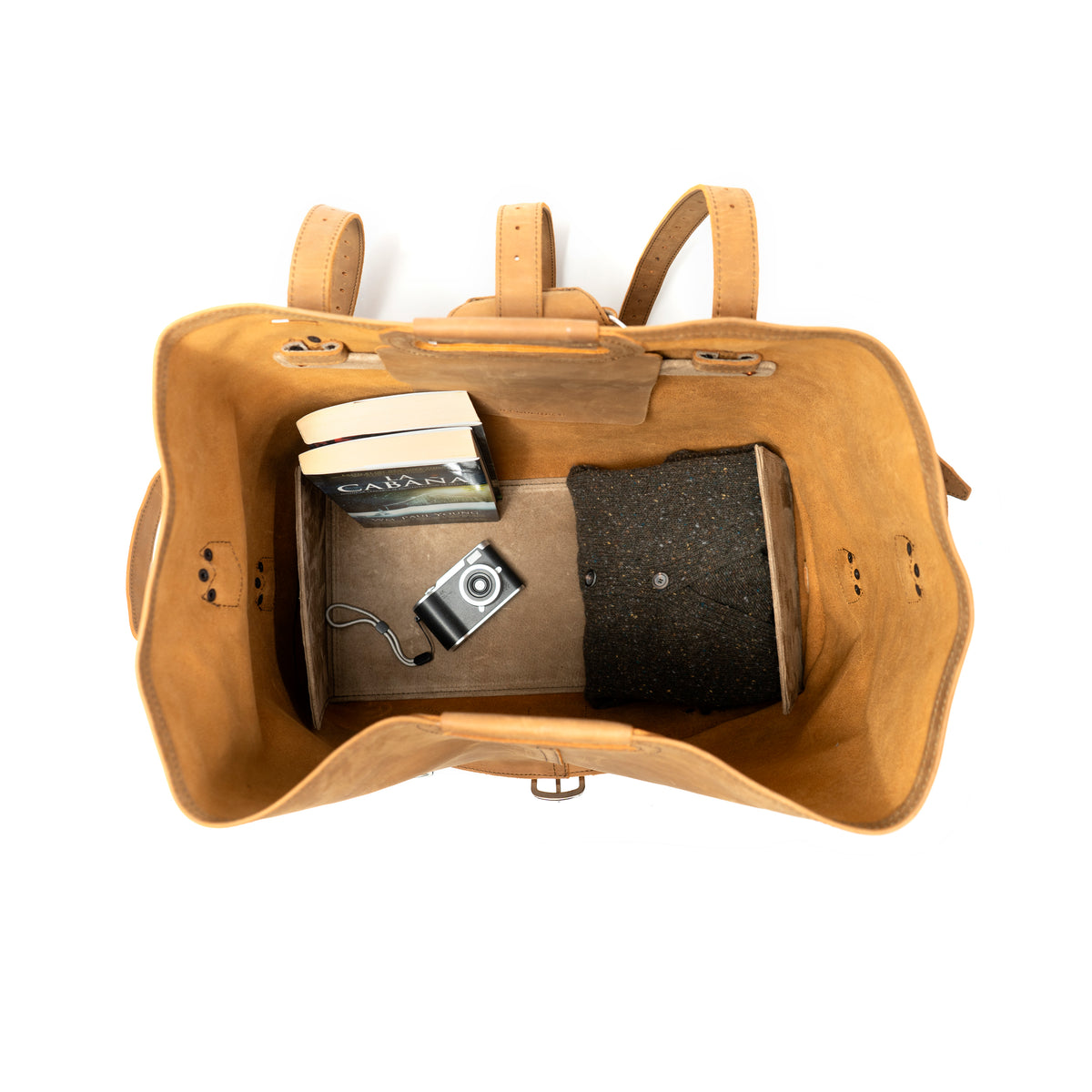 20" Waterbag in Tan, open top-down view of interior with books, camera and a sweater