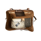 24" Waterbag in dark brown, top-down view inside packed with blankets, books and a camera