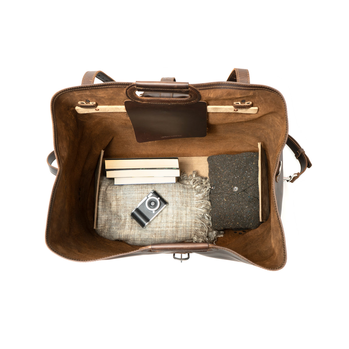 24" Waterbag in dark brown, top-down view inside packed with blankets, books and a camera