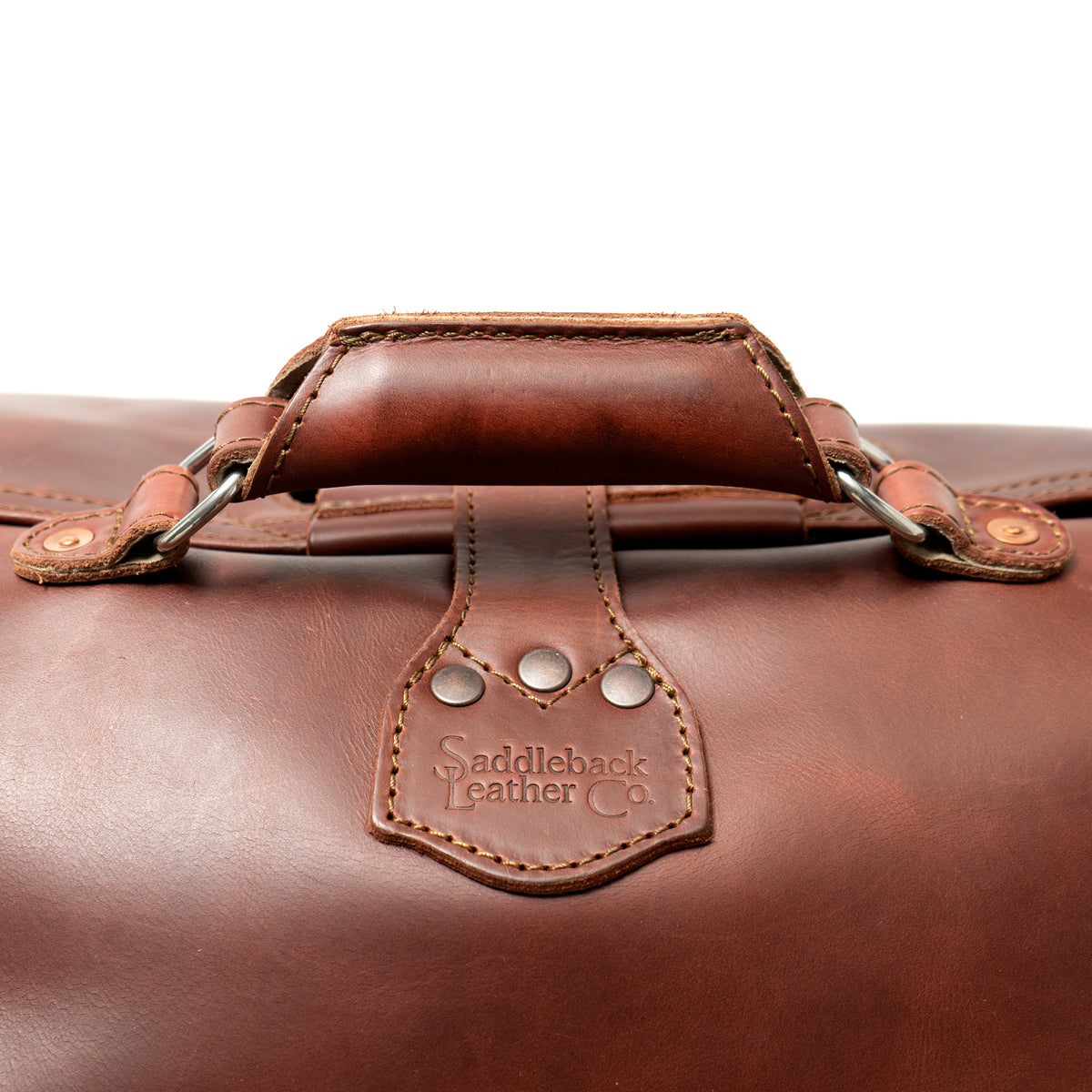 24" Waterbag in reddish brown, close-up of the padded top handle and riveted logo tab