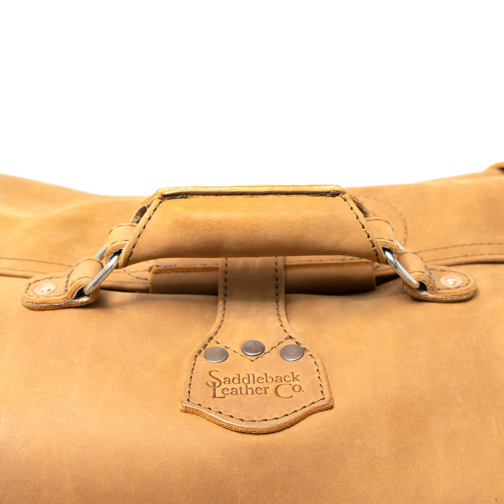 24" Waterbag in tan, close-up of the padded top handle and riveted logo tab