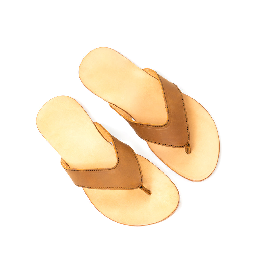 Pair of Flip Flops in Tobacco leather with V-shaped thong straps and natural footbeds, top-down view