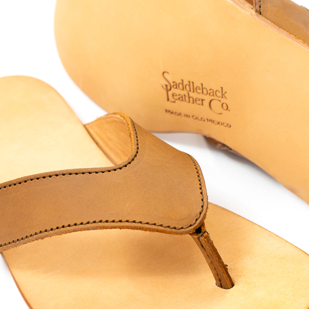 Close-up of Flip Flops in Tobacco leather showing the strap and Made in Old Mexico logo stamp on the sole