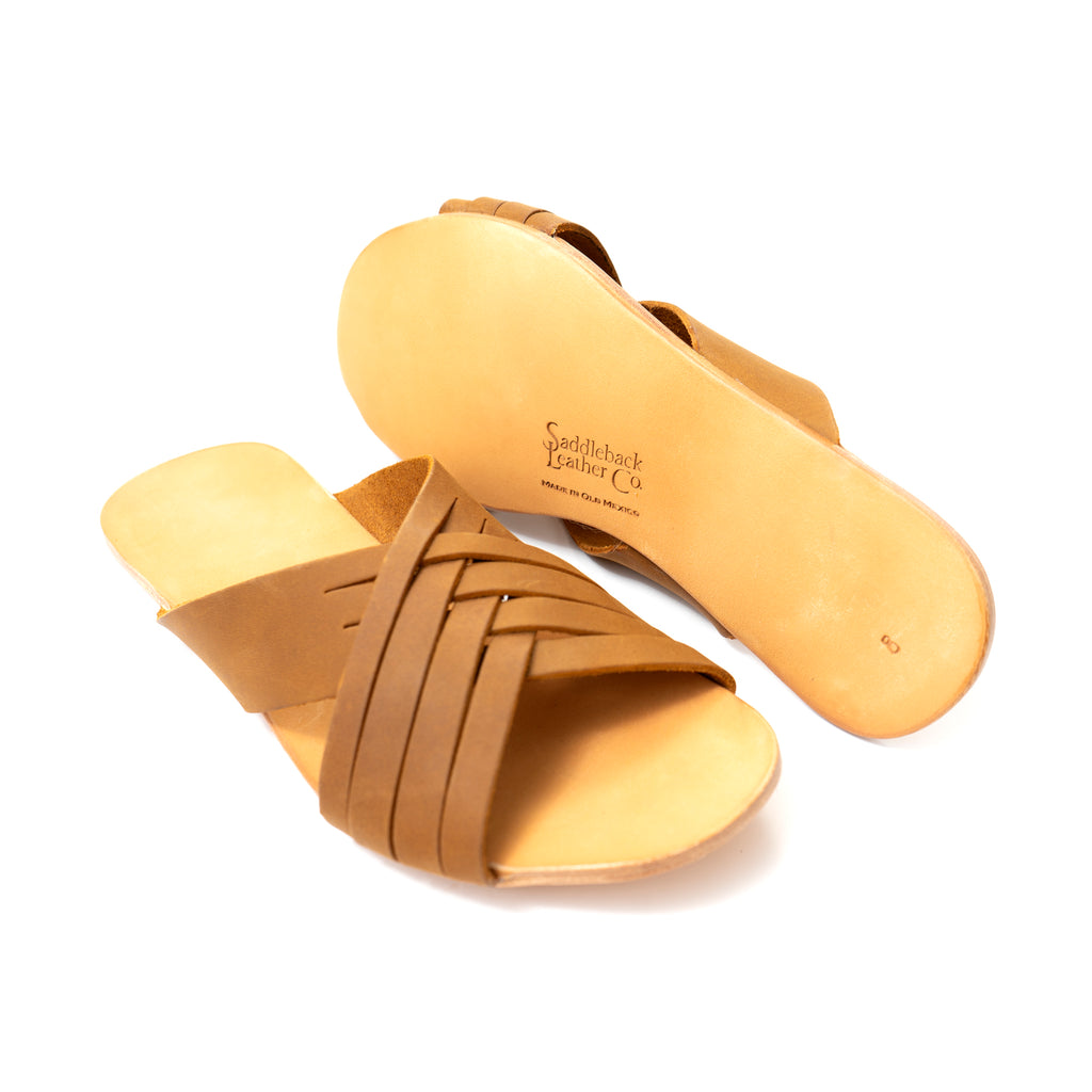 Martha Sandals in Tobacco, pair with one sandal flipped to show the sole and stamped logo