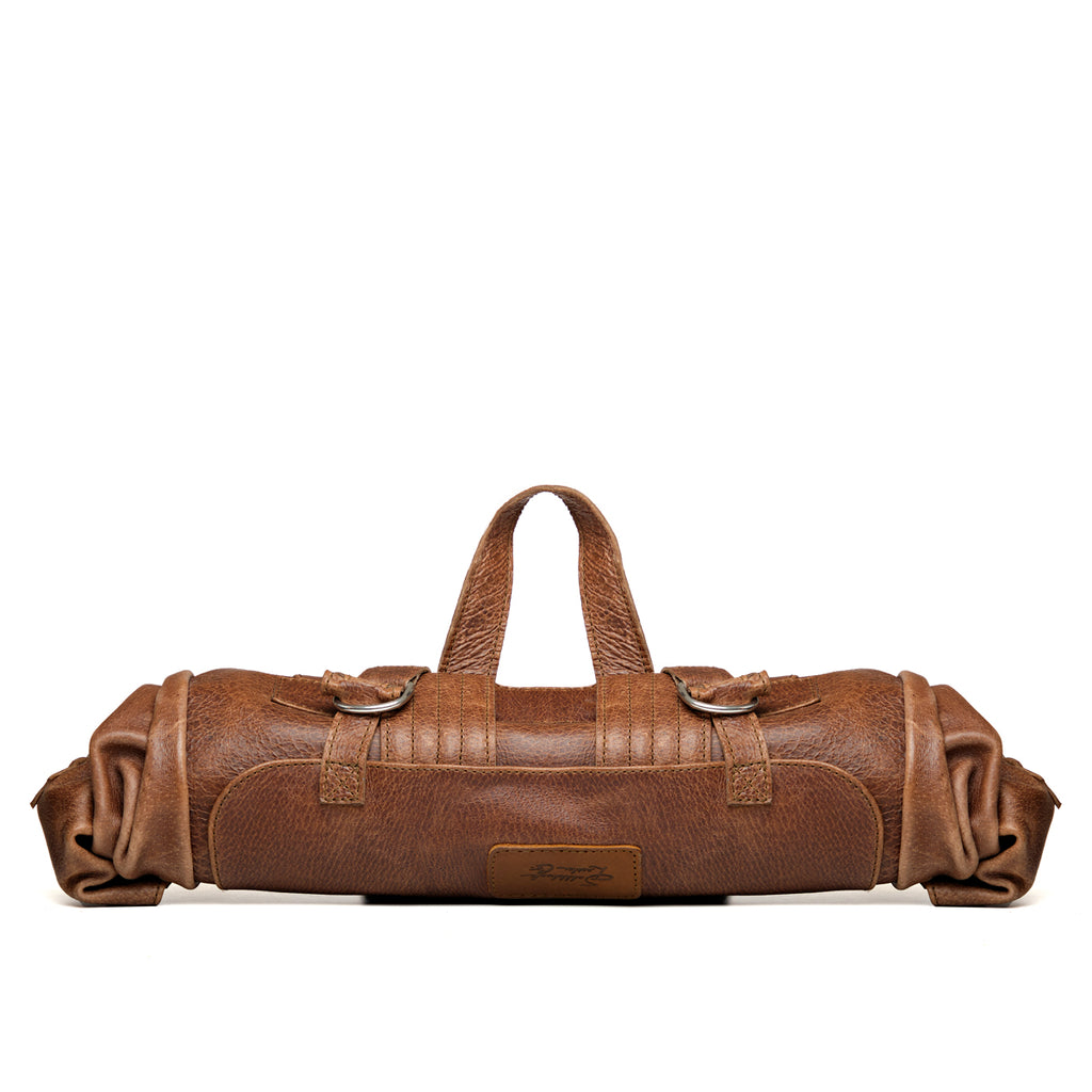 Large Travel Backpack in Burnt Sausage, rolled up with the top handle raised