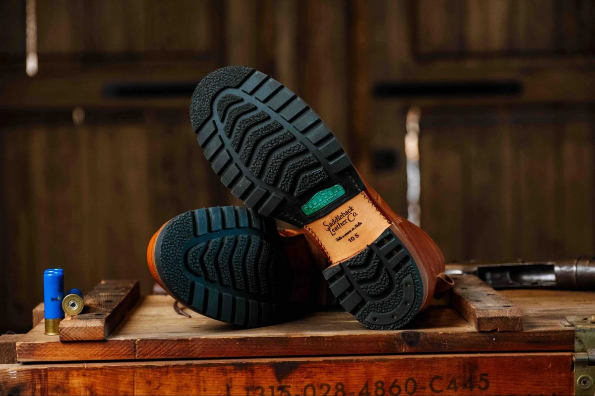 Huntsman Boots - Natural lying on a wooden crate, showing the lugged rubber outsoles and logo-stamped heels