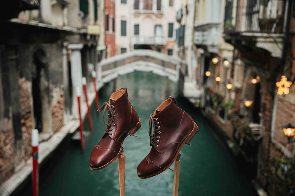 Officer Boot in Oxblood, pair on wooden stands above a Venice canal