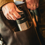 16" Drawstring Backpack in Dark Coffee Brown, hands sliding an insulated tumbler into the side pocket