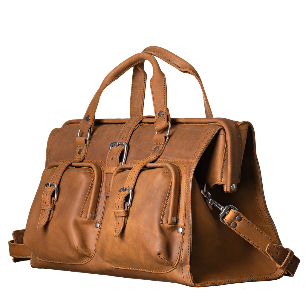 Deep Pocket Leather Duffle Bag in Tobacco, angled front view with two buckled front pockets