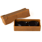 Grandfather Eyeglass Case in Tobacco leather, open with a pair of round sunglasses inside and lid beside it