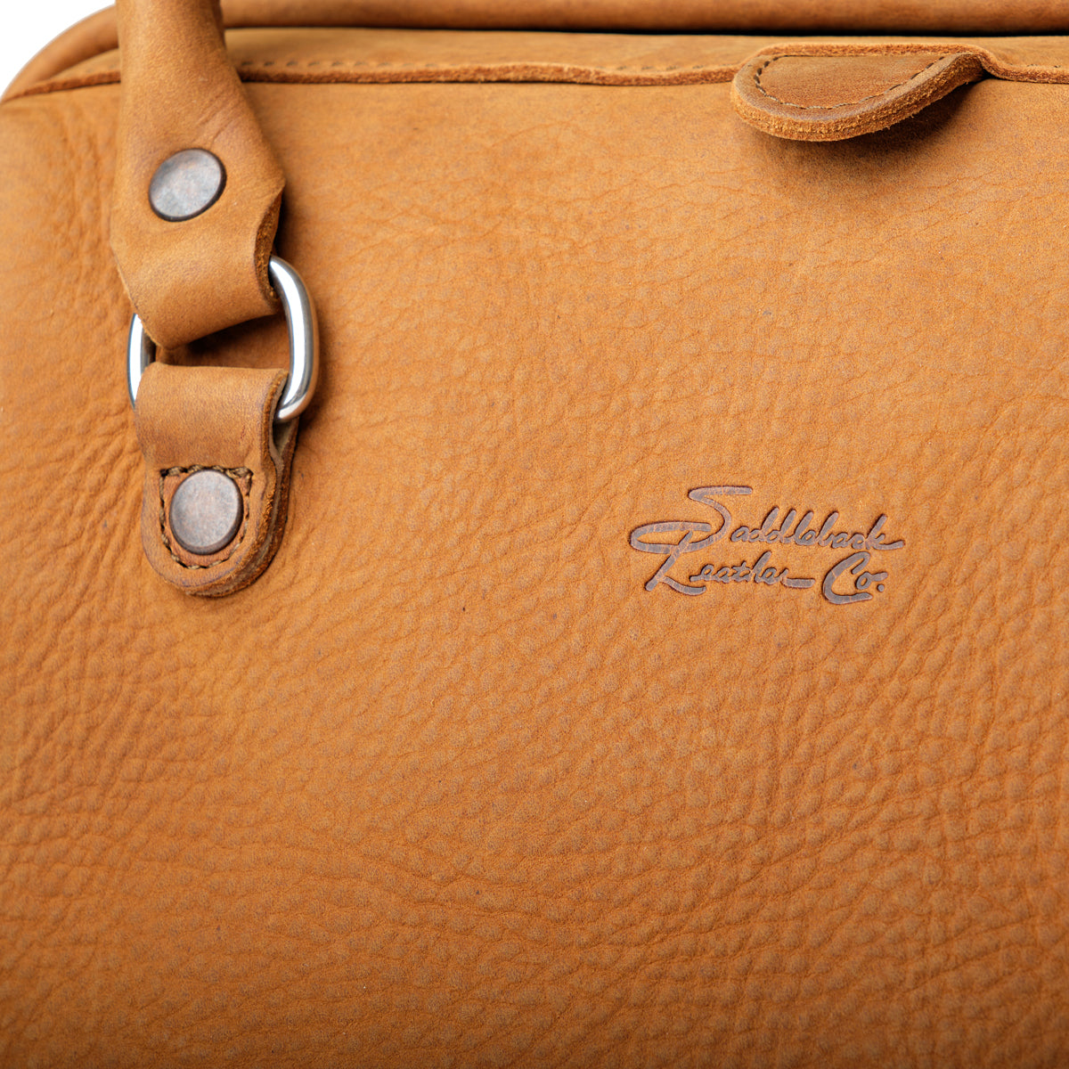 Everyday Purse in Tobacco, close-up of the embossed Saddleback Leather Co. logo and riveted handle ring