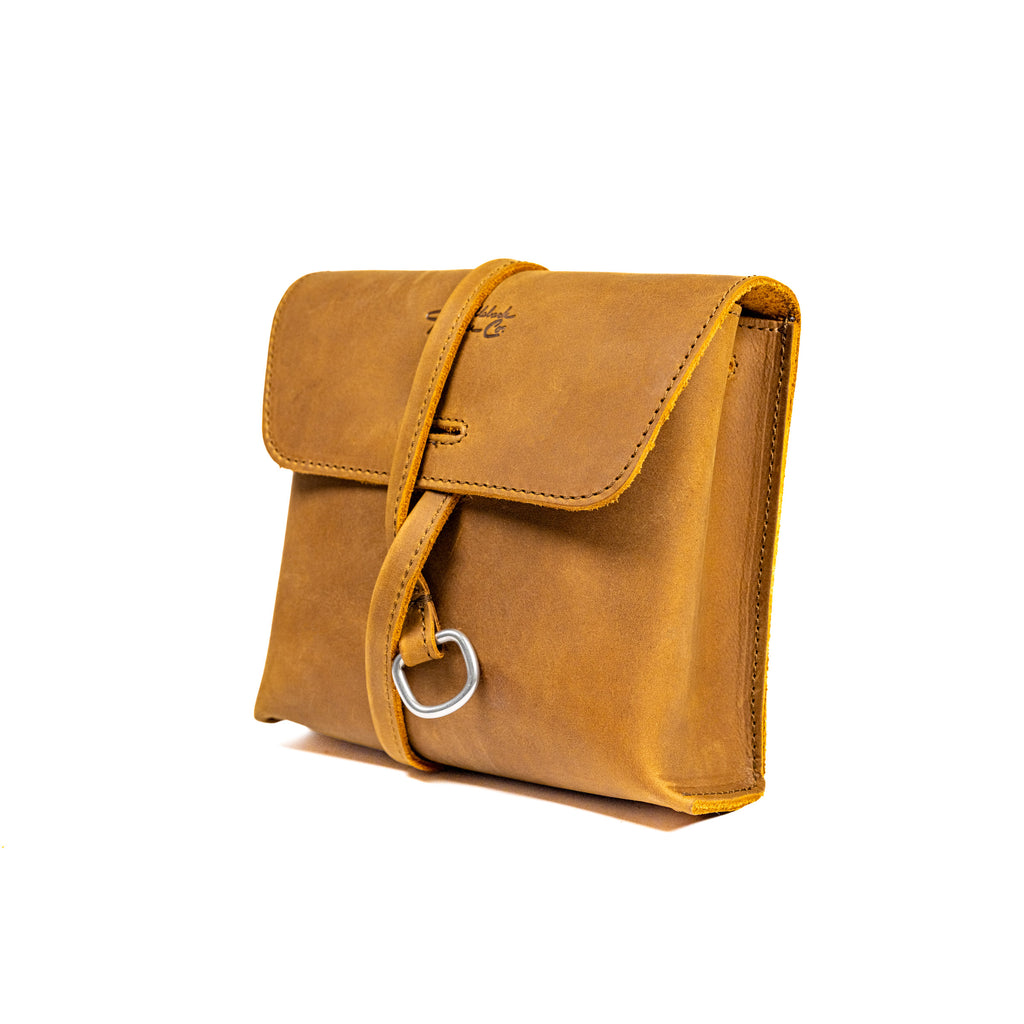 Leather Organizer Bag in Tobacco, three-quarter view with flap closure and strap wrapped around the front