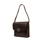 Leather Organizer Bag in Dark Coffee Brown, angled view hanging from its strap with flap and metal ring closure