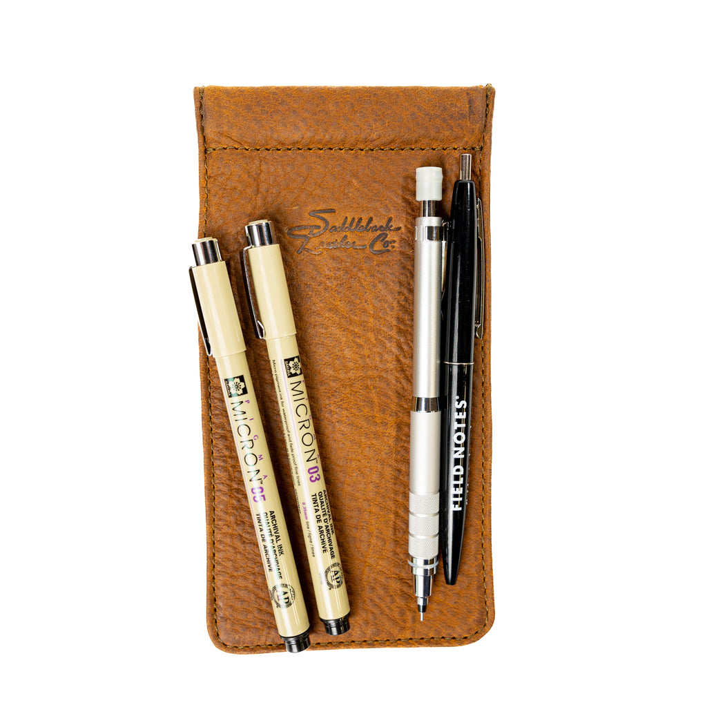 Bear Trap Leather Pen Case in Tobacco lying flat with fine-liner pens, a mechanical pencil and a pen on top