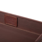 Grandfather Serving Tray in Chestnut leather, close-up of stitched Grandfather Collection patch on the inner wall