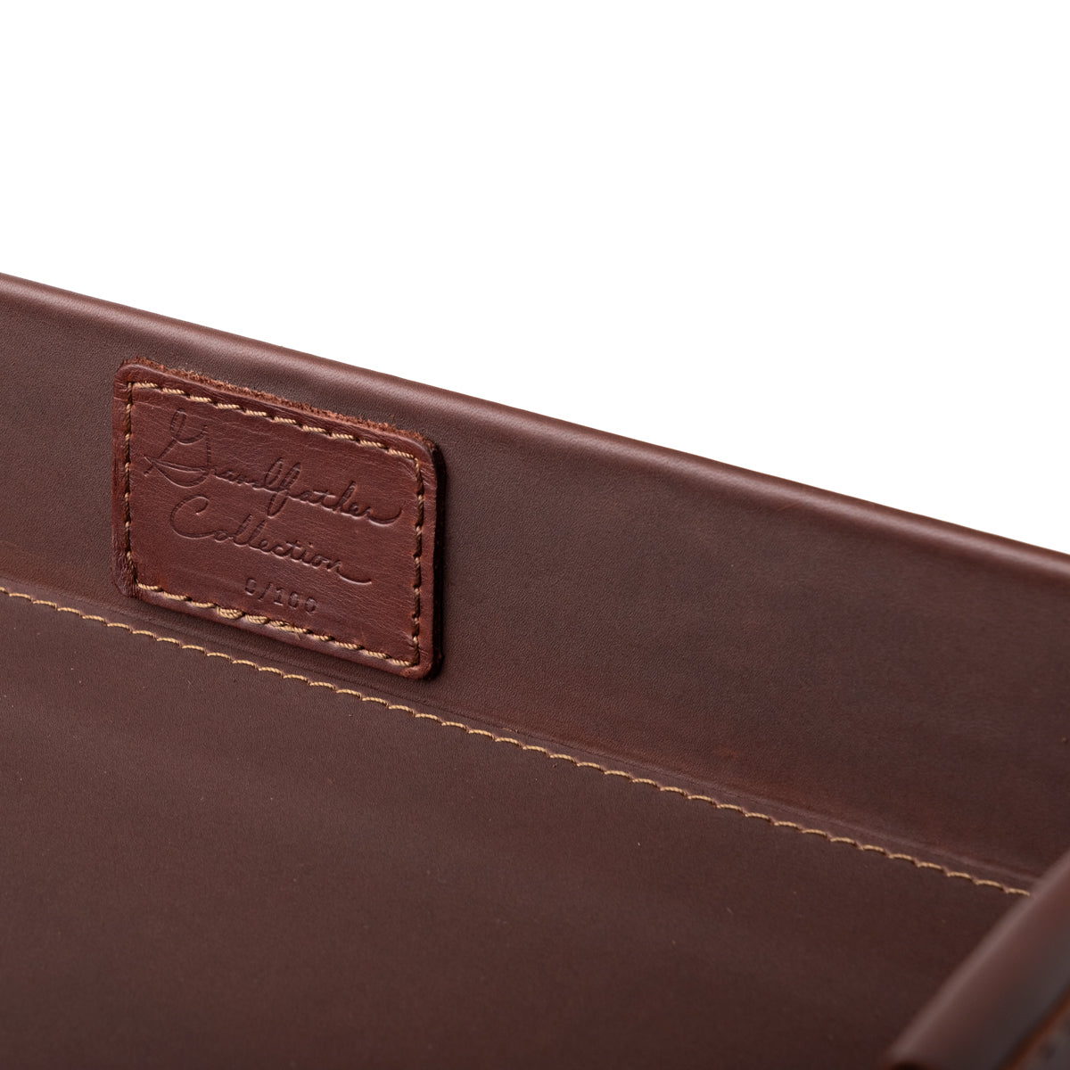 Grandfather Serving Tray in Chestnut leather, close-up of stitched Grandfather Collection patch on the inner wall