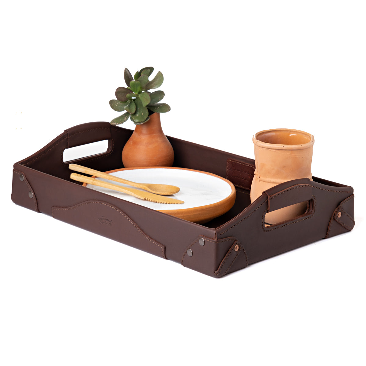 Grandfather Serving Tray in Chestnut leather holding a plate, wooden utensils, a terracotta cup and a potted succulent