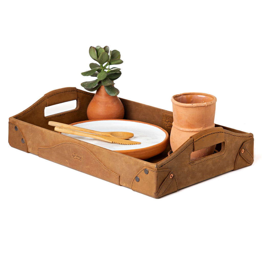 Grandfather Serving Tray in Tobacco leather holding a plate, wooden utensils, a terracotta cup and a potted succulent