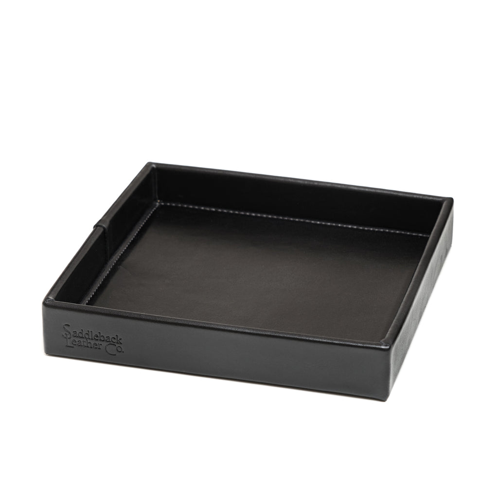 The Simple Leather Valet Tray in Black, empty, angled view showing stitched corner seams and embossed logo