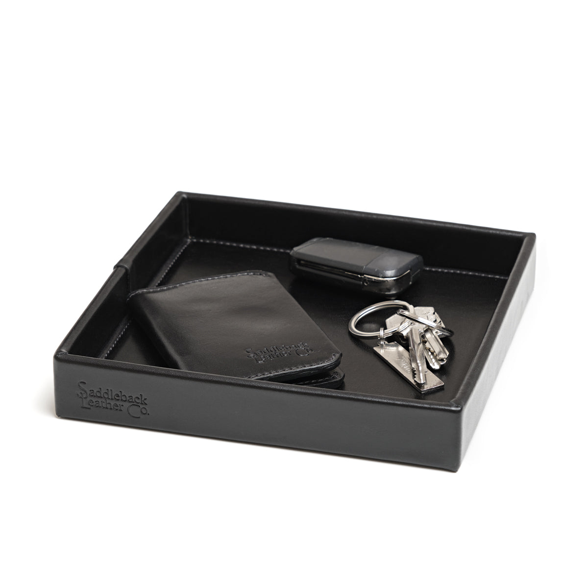 The Simple Leather Valet Tray in Black holding a leather card wallet, key fob and keys, angled view
