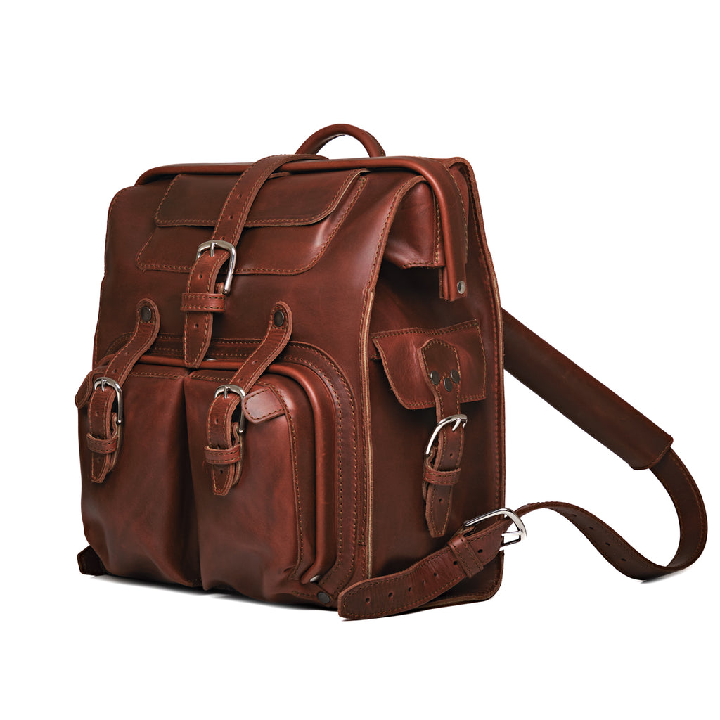 Big Mouth Leather Backpack in Chestnut, angled front view with buckled pockets and shoulder strap