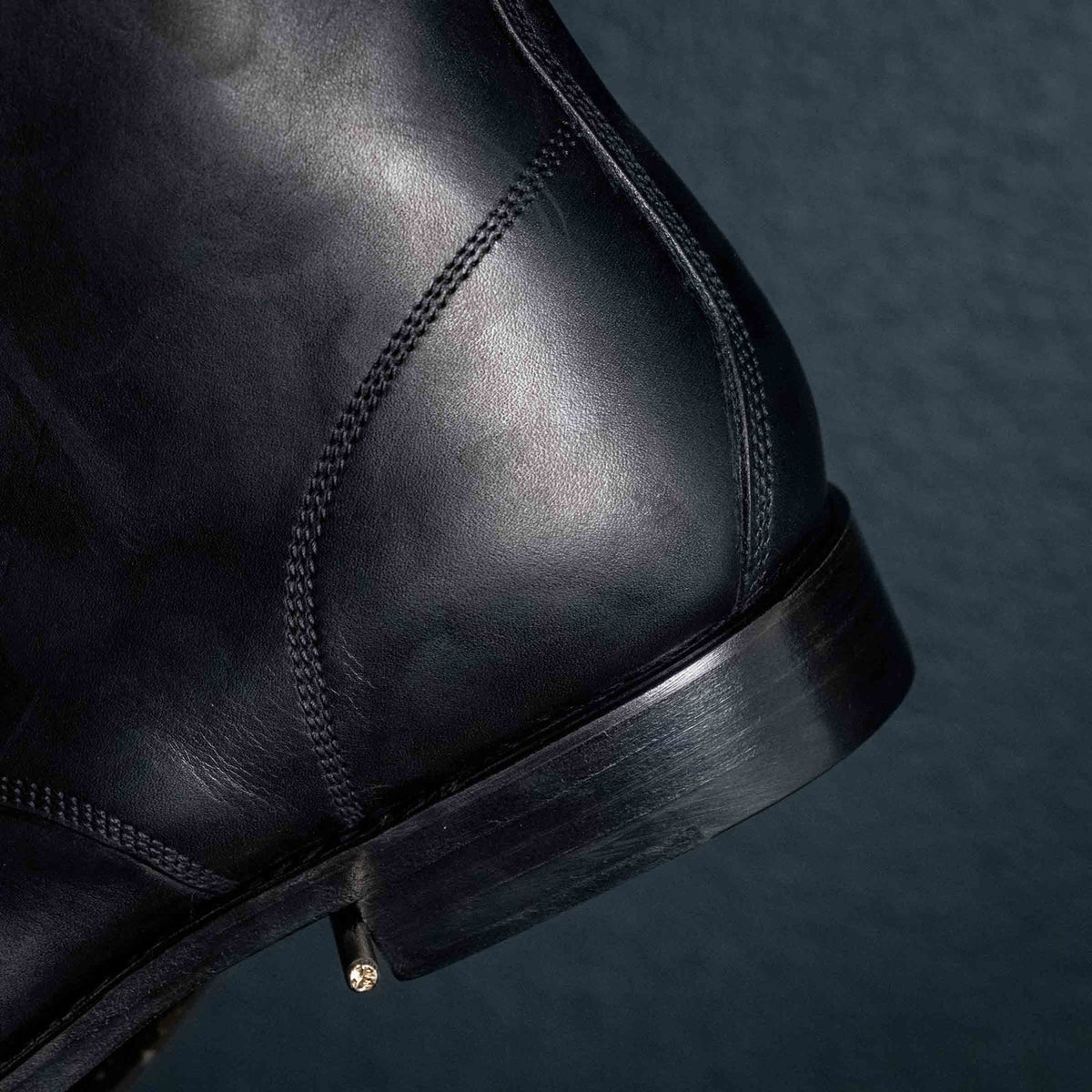 Close detail of the stacked heel and counter stitching on a high quality black leather Officer Boot