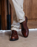 Toe Cap Shoes in Dark Oak, worn with one foot forward in front of a wooden door