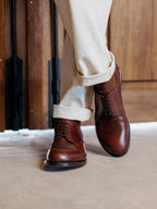 Toe Cap Shoes in Dark Oak, worn with legs crossed in front of a wooden door