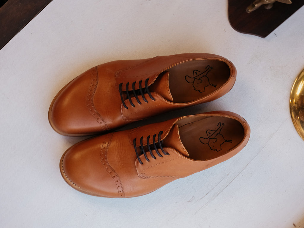 Toe Cap Shoes in English Tan, overhead view of the pair side by side on a white surface