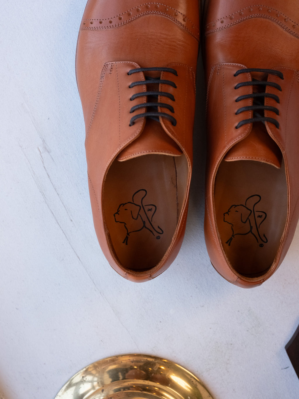 Toe Cap Shoes in English Tan, top-down view of the pair showing dog logo insoles