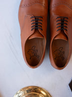 Toe Cap Shoes in English Tan, top-down view of the pair showing dog logo insoles