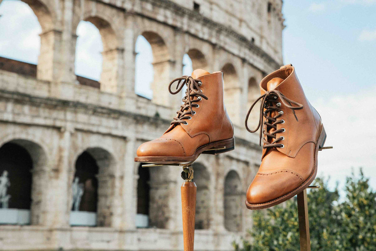 Pair of high quality English tan leather Officer's Boots on stands in front of the Colosseum in Rome