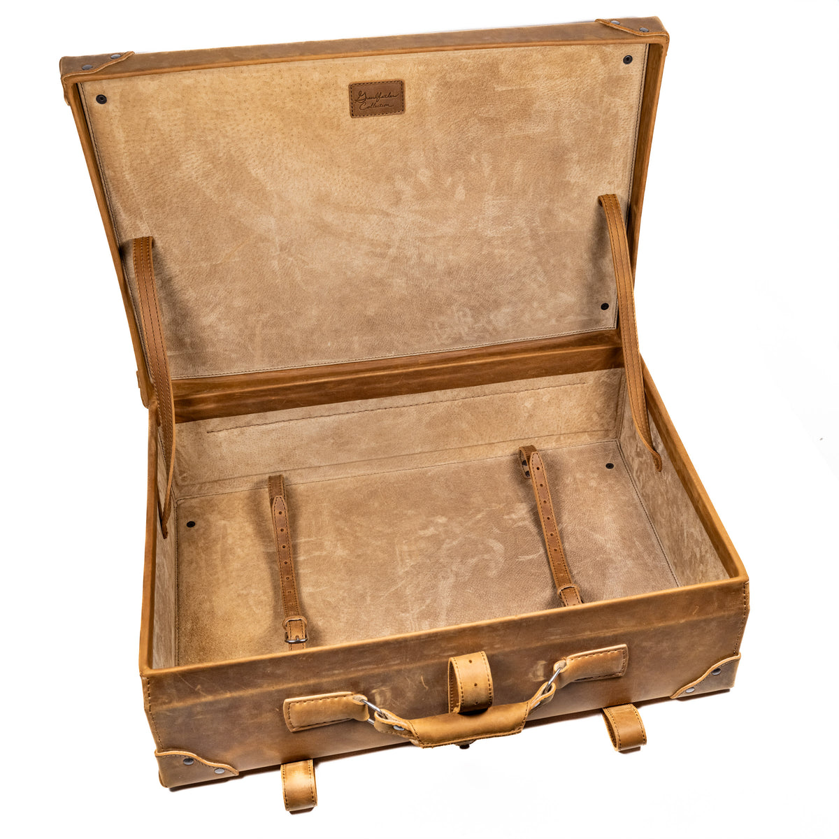 Grandfather Suitcase in Tobacco, opened to show the canvas lining and leather tie-down straps